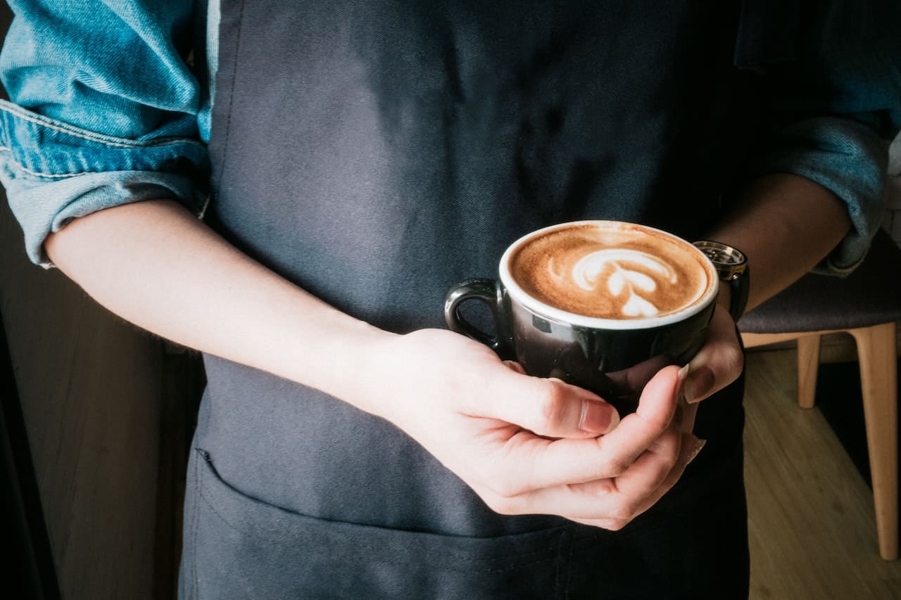 barista with coffee in hand